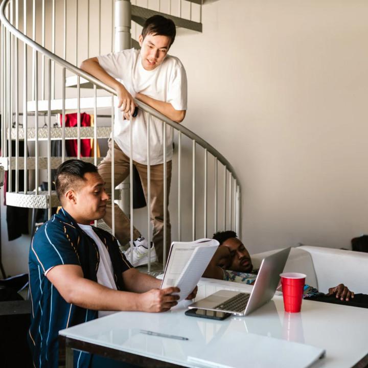 Men working and chatting in a living room stock image after moving out