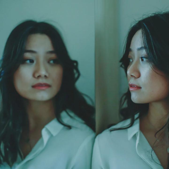 Woman staring at her reflection in the mirror after moving out