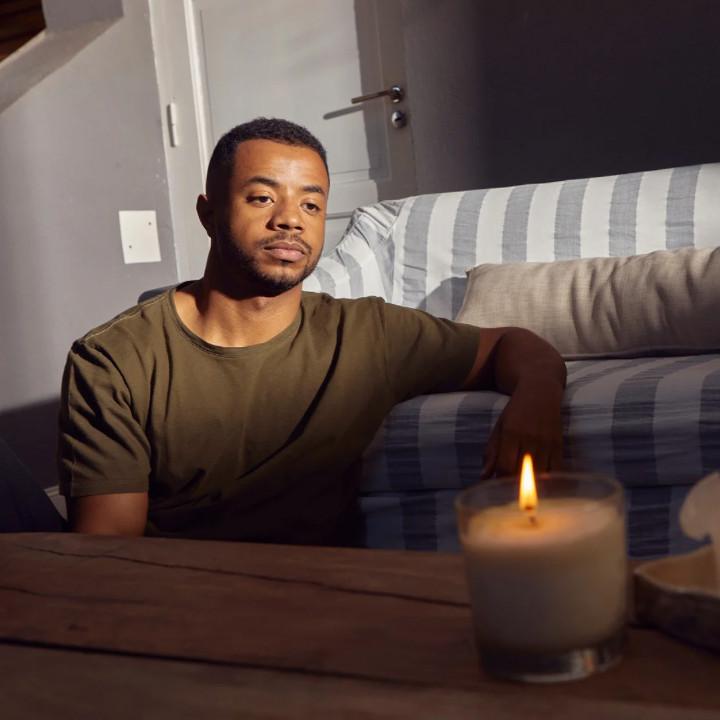 Man sitting alone in the living room as he’s moved out and is living alone for the first time